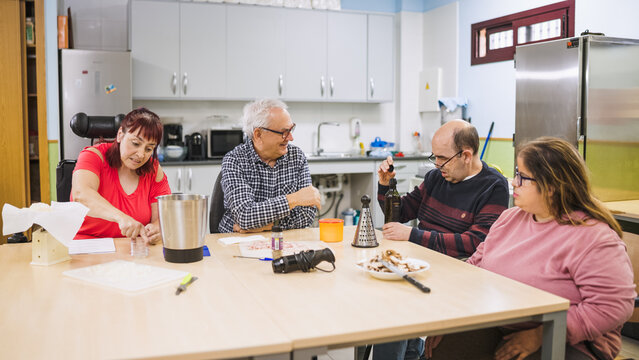 Diverse adults with disabilities participating in a cooking workshop in a kitchen, focusing on independent daily living skills