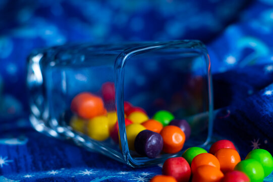 Close up of candy in glass. The glass is shaped like a square. 