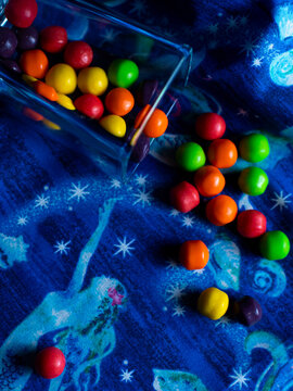 Multi colored small bite sized candies on a blue background.