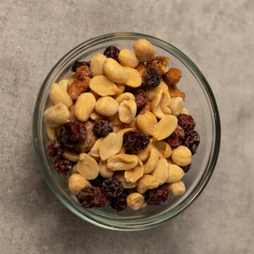 Raisins, peanuts and cashews in a bowl from above.