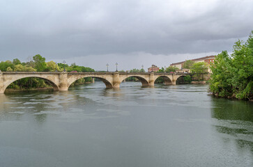 Fototapeta premium Ebro River cityscape in Logrono, Spain, under cloudy daytime sky