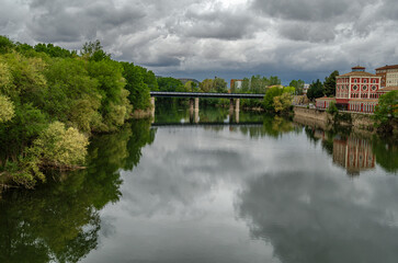 Fototapeta premium Ebro River cityscape in Logrono, Spain, under cloudy daytime sky