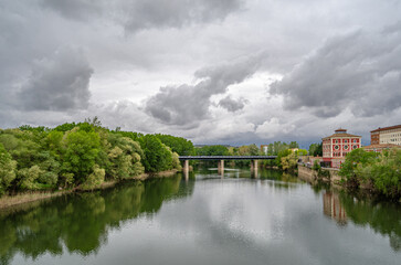 Fototapeta premium Ebro River cityscape in Logrono, Spain, under cloudy daytime sky