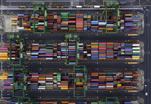 Aerial view of a vibrant tapestry of shipping containers stacked in neat rows, creating a geometric mosaic of colors and textures at the harbor, Singapore, Singapore.