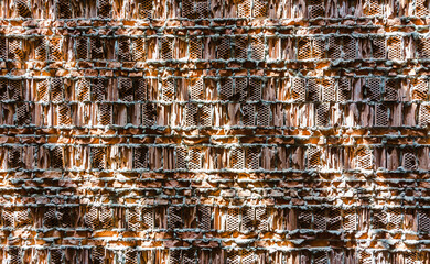 Red ceramic hollow brick wall texture with unique light and shadow pattern.