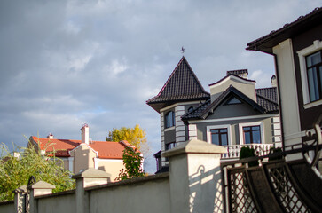Obraz premium Elegant Houses in Residential Area on Cloudy Day under Dramatic Sky