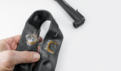 Bike Inner tube with a fixed punctures. The pump on a white