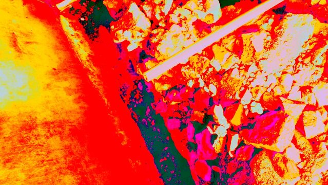 Abstract high-contrast background with vibrant red and yellow fiery highlights over dark rugged stone and industrial textures
