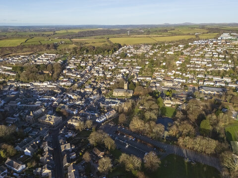 Aerial view of a historic town nestled amidst rolling green fields, with the church steeple piercing the skyline, Bodmin, England, United Kingdom.