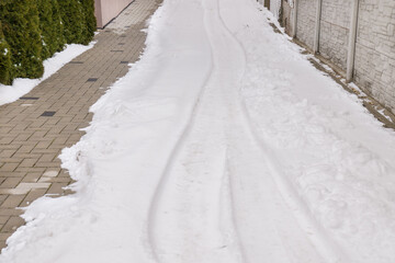 Fototapeta premium Snow in the house driveway in the end of the winter. Snow melting