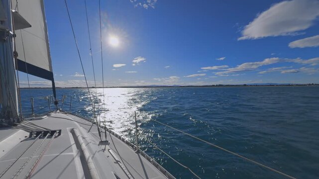 Valencia sailboat sailing on Mediterranean Sea with sun reflections