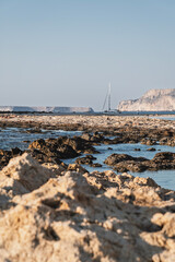 Sunny Balos Lagoon in Crete with turquoise water, rocks and mountains in background.