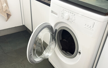  open door washing machine on a white and wood background