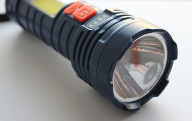 Rubberized body parts and protective covers on the buttons of a handheld dustproof camping flashlight 
