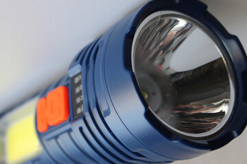 Close up stock photo of the lens with the head LED of a handheld flashlight in a rubberized housing with a high level of water resistance 
