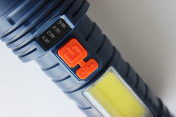 Battery level indicator lights and a large LED floodlight element of a pocket flashlight
