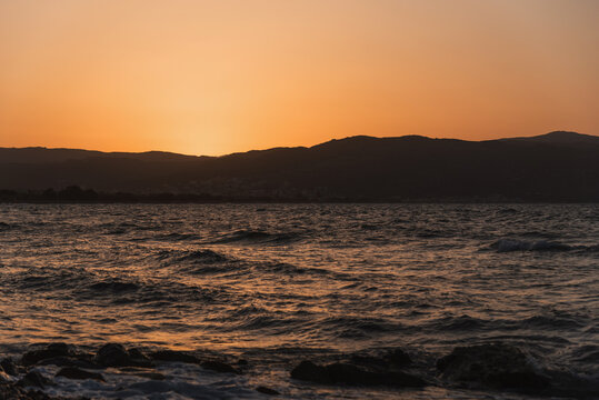 Sea panorama at sunset with waves washing over the stony beach shore
