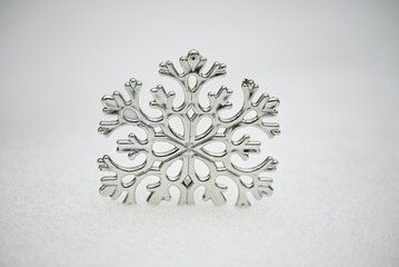Silver Christmas  toy snowflake on a snow background