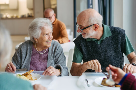 Elderly couple having lunch in community center cafeteria.