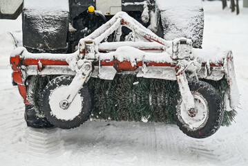 Snow removal tractor cleans road in winter park