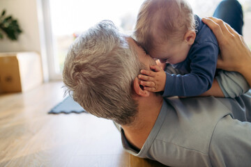 Father playing with little son on floor.