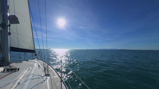 Valencia sailboat sailing on Mediterranean Sea with sun reflections