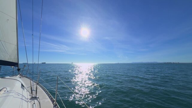 Valencia sailboat sailing on Mediterranean Sea with sun reflections