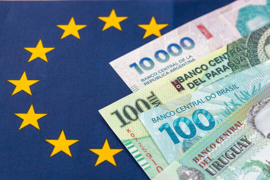 Mercosur trade agreement with the European Union. Business concept. Banknotes of Brazil, Argentina, Paraguay, and Uruguay against the backdrop of the European Union flag