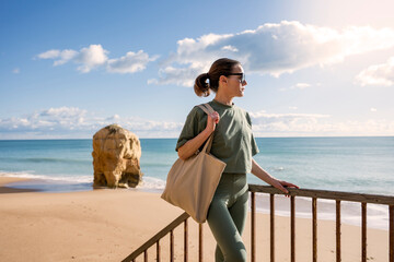 sporty woman with tote bag at the beach