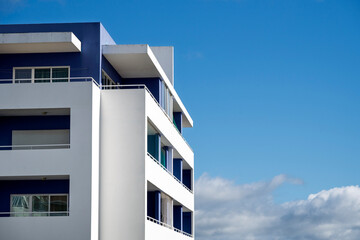 blue and white apartment block against blue sky