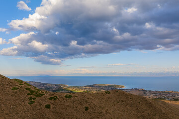 Aerial view captures expansive landscape of coastal town Cholpon-Ata with Issyk-Kul lake and mountains in the distance.