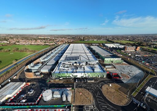 Aerial view of the sprawling Google AI data centre complex, a modern industrial landscape contrasting against the surrounding greenery, Waltham Cross, United Kingdom.