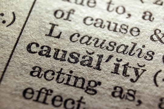 Word causality printed on dictionary page, macro close up