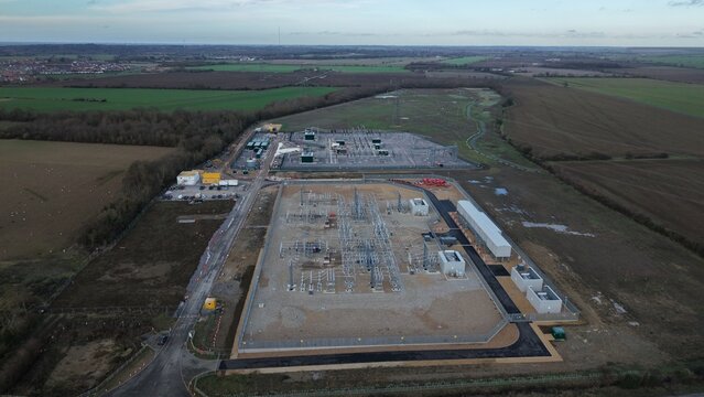 Aerial view of the substation's stark geometry against the soft, muted tones of the surrounding landscape, Biggleswade, Biggleswade, United Kingdom.