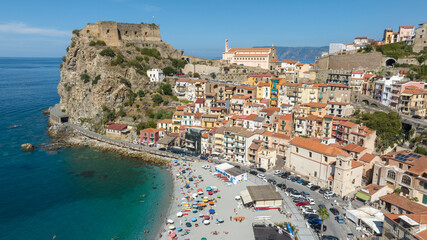 Fototapeta premium Aerial view of the historic center of the town of Scilla, in Calabria, Italy. Panorama of a beautiful village located on a promontory overlooking the Mediterranean Sea. In foreground it's the beach.