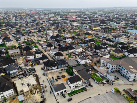 Aerial view of rooftops and roads creating a dense urban tapestry under a soft, overcast sky, Ede Okia Community Road, Port Harcourt, Rivers, Nigeria.