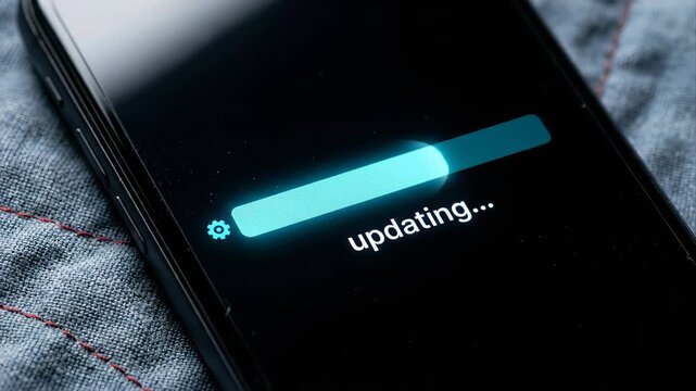Close up of a mobile phone screen showing a glowing progress bar during a system or application software update, symbolizing technology advancement and data installation on a modern device