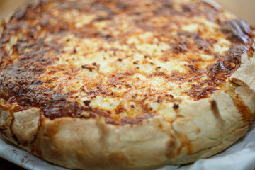 Homemade baked cheese pie or quiche with golden brown crust. Savory pastry dish close up.