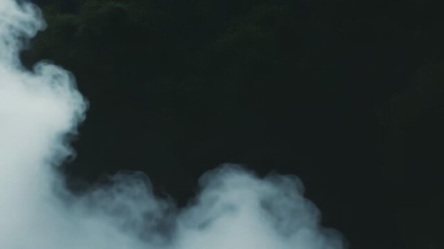 Dense grey smoke and fog billow and swirl across the frame, forming an ominous, smooth gradient abstract background with soft, ethereal texture and moody atmospheric depth