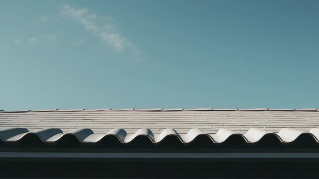 Building roof tiles creating a linear pattern contrasting with a vast, serene blue sky, providing ample copy space, a clean design, and a minimalist aesthetic