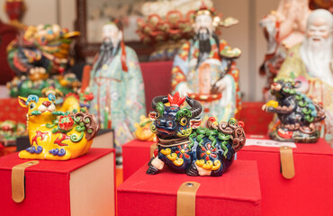 Chinese New Year market featuring traditional Asian talismans, including feng shui items, candles, dragons, lucky cats, jade ornaments, coins, souvenirs celebrating prosperity and good fortune