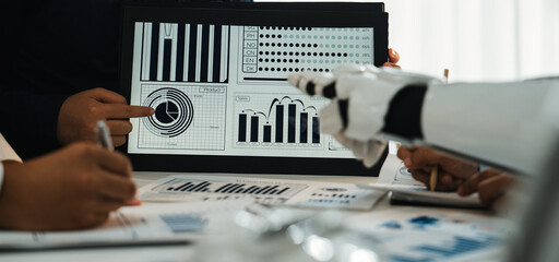 A diverse group of professionals engages in a collaborative analysis of data trends on a tablet....