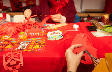 Chinese New Year papercutting workshop - create traditional festive symbols and Chinese characters from red paper. Cultural craft activity celebrating Lunar New Year traditions