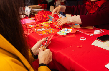 Chinese New Year papercutting workshop - create traditional festive symbols and Chinese characters from red paper. Cultural craft activity celebrating Lunar New Year traditions