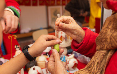 Chinese New Year candle workshop - create traditional festive symbols and Chinese characters from red paper. Cultural craft activity celebrating Lunar New Year traditions