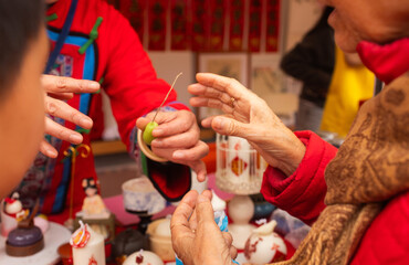 Chinese New Year candle workshop - create traditional festive symbols and Chinese characters from red paper. Cultural craft activity celebrating Lunar New Year traditions