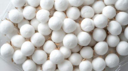 A large pile of unopened sterile white cotton balls in their packaging a close up overhead view