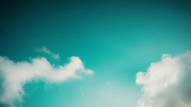 Pastel blue and green sky with soft, diffuse clouds forming a natural frame around an ethereal light, offering a tranquil and airy feeling with ample copy space