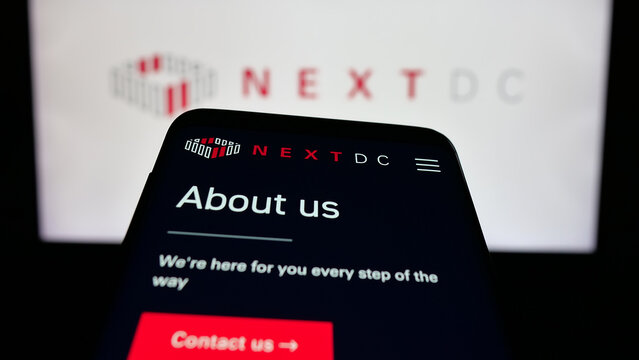 Stuttgart, Germany - 01-21-2026: Mobile phone with website of Australian data center company NextDC Ltd. on screen in front of logo. Focus on top-left of phone display.