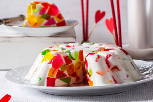 A cream cake with jelly pieces of different colors on a light background. Valentine's Day dessert.